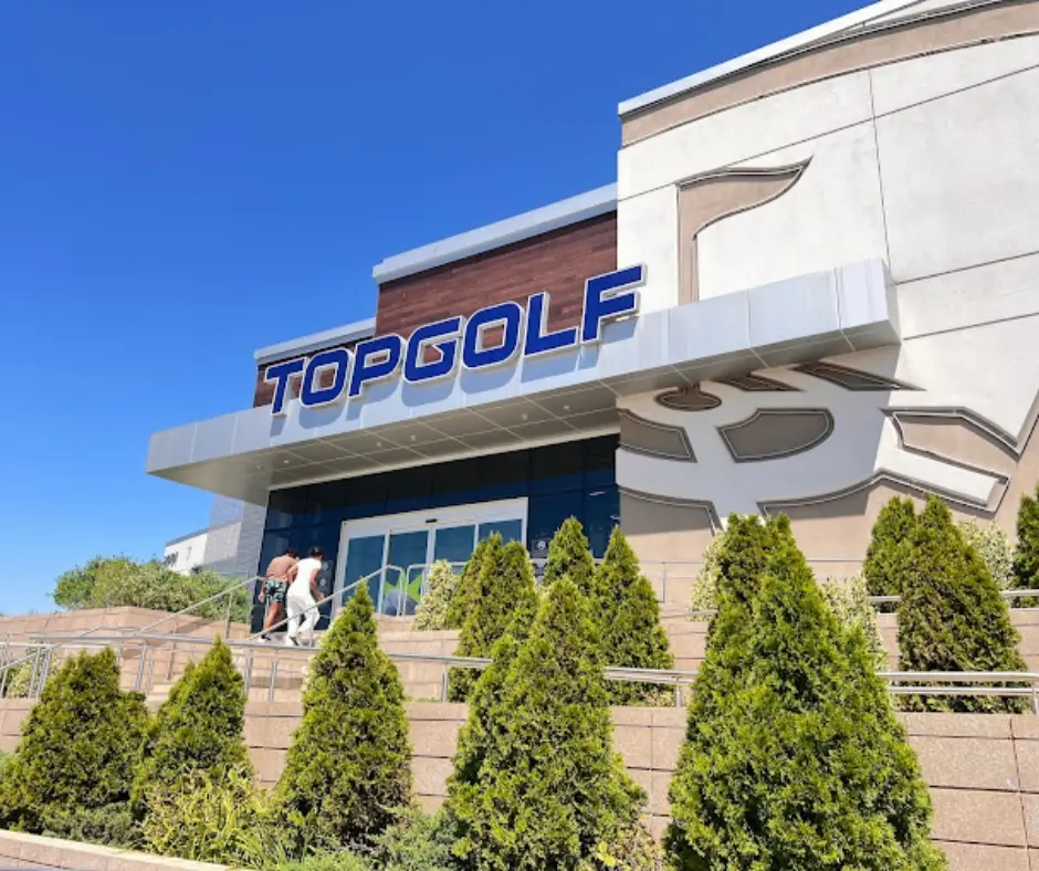 An inviting view of golfers practicing their swings at a well-lit Topgolf range in Germantown, MD.